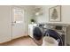 Functional laundry room with modern washer and dryer, storage cabinets, and a door to the outside at 1565 Briergate Dr, Duluth, GA 30097