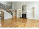 Bright living room with hardwood floors and an elegant staircase featuring a marble fireplace and built-in shelving at 1565 Briergate Dr, Duluth, GA 30097