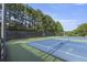 Community tennis courts surrounded by a tall fence and several trees for privacy at 1565 Briergate Dr, Duluth, GA 30097