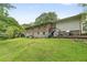 Grassy backyard, brick and light siding, with mature trees and a slide at 2720 Birchwood Sw Way, Marietta, GA 30060