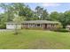 Charming brick home with a lush green lawn and mature trees providing shade at 2720 Birchwood Sw Way, Marietta, GA 30060