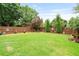 Landscaped backyard with a wooden fence, mature trees, and verdant lawn at 4312 Shillham Ct, Cumming, GA 30040