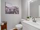 Chic powder room featuring a white vanity, modern faucet, a decorative mirror, and a stylish Highland cow print at 4312 Shillham Ct, Cumming, GA 30040