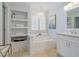 Bright bathroom with built-in shelving, soaking tub, modern fixtures, and plenty of light at 4312 Shillham Ct, Cumming, GA 30040