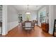 Bright dining room featuring hardwood floors, wainscoting, a large dining table, and an elegant chandelier at 4312 Shillham Ct, Cumming, GA 30040