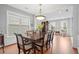 Spacious dining room with hardwood floors, wainscoting, an elegant chandelier, and a large dining table at 4312 Shillham Ct, Cumming, GA 30040