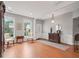 Bright living room featuring hardwood floors, an armoire, neutral walls, large windows, and an elegant lighting fixture at 4312 Shillham Ct, Cumming, GA 30040