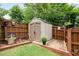 Well-maintained outdoor storage shed with a neutral color scheme and double doors in a fenced backyard setting at 4312 Shillham Ct, Cumming, GA 30040