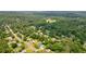 Wide aerial shot showcasing a home nestled in a lush, wooded neighborhood with mature trees and surrounding residences at 117 Village Ct, Woodstock, GA 30188