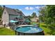 Backyard featuring an above-ground pool with attached deck, patio furniture, and plenty of green space at 117 Village Ct, Woodstock, GA 30188