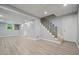 Finished basement with laminate floors, white walls, and modern black metal staircase railing at 117 Village Ct, Woodstock, GA 30188