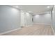 Finished basement features laminate floors, white walls, and a door leading to another room at 117 Village Ct, Woodstock, GA 30188