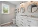 Bright bathroom featuring double vanity, shiplap walls, and modern mirrors hanging from rope at 117 Village Ct, Woodstock, GA 30188