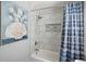 Modern bathroom with a white tile shower, blue shower curtain, and decorative shell art at 117 Village Ct, Woodstock, GA 30188