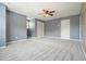 Spacious bedroom featuring gray walls, carpet flooring, ceiling fan, and closet with paneled doors at 117 Village Ct, Woodstock, GA 30188