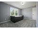 Cozy bedroom features carpet flooring, a modern bed frame, and natural lighting from the windows at 117 Village Ct, Woodstock, GA 30188