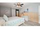 Modern bedroom with wood accent wall, ceiling fan, white dresser, and barn door mirror at 117 Village Ct, Woodstock, GA 30188