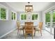 Cozy dining room with light wood table and chairs, a modern light fixture, and sliding glass door at 117 Village Ct, Woodstock, GA 30188