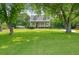 Traditional home with a large front yard, mature trees, and a welcoming front porch at 117 Village Ct, Woodstock, GA 30188