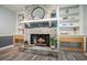 Living room fireplace featuring stone surround, wood mantel, and built-in shelving with accent lighting at 117 Village Ct, Woodstock, GA 30188