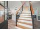 Welcoming foyer with stairs, hardwood floors, and a view of the renovated kitchen at 117 Village Ct, Woodstock, GA 30188