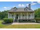 Charming home with a covered front porch, white railings and columns, and a well-maintained lawn at 117 Village Ct, Woodstock, GA 30188