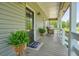 Cozy front porch featuring wicker rocking chairs, decorative plants, and a welcome mat at 117 Village Ct, Woodstock, GA 30188