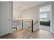 Modern hallway with wood floors, black metal railing, and a view into the adjacent bedroom at 117 Village Ct, Woodstock, GA 30188
