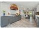 Modern kitchen with gray cabinets, white countertops, a wooden range hood and stainless steel appliances at 117 Village Ct, Woodstock, GA 30188