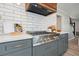 Close-up of a range with stainless steel appliances, quartz countertops and subway tile backsplash at 117 Village Ct, Woodstock, GA 30188