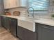 Close-up of a bright kitchen with a farm sink, quartz countertops, and a subway tile backsplash at 117 Village Ct, Woodstock, GA 30188