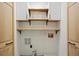 Well-organized laundry room with white cabinets, wooden shelves, and stylish wooden doors at 117 Village Ct, Woodstock, GA 30188