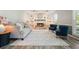 Bright living room with a stone fireplace, built-in shelves, gray sofa, and blue accent chairs at 117 Village Ct, Woodstock, GA 30188