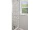 Modern shower with marble tile, a bench, and mosaic tile flooring with natural light at 117 Village Ct, Woodstock, GA 30188