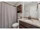 A neutral bathroom with a granite countertop, dark wood vanity and cabinet, and a shower/tub with a striped curtain at 5070 Laurel Ridge Dr, Cumming, GA 30040