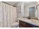 Well-lit bathroom featuring granite countertops, a floral shower curtain, and a dark wood vanity at 5070 Laurel Ridge Dr, Cumming, GA 30040