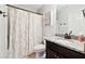 Well-lit bathroom features granite counters, dark cabinets, and a shower-tub combo with a floral curtain at 5070 Laurel Ridge Dr, Cumming, GA 30040