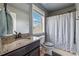 Bathroom featuring granite counters, dark cabinets, tub-shower combo, natural light and blue-grey color palette at 5070 Laurel Ridge Dr, Cumming, GA 30040