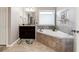 Relaxing bathroom featuring a standalone bathtub, granite countertops, dark wood cabinets, and tile flooring at 5070 Laurel Ridge Dr, Cumming, GA 30040