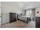 Cozy bedroom featuring a dark wood dresser and a comfortable bed with a gray and white checkered comforter at 5070 Laurel Ridge Dr, Cumming, GA 30040
