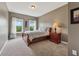 A well-lit bedroom with carpet, a bedside table, and two large windows with nice backyard views at 5070 Laurel Ridge Dr, Cumming, GA 30040