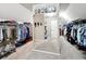 Large walk-in closet featuring double hanging racks, shelves, and a dressing area at 5070 Laurel Ridge Dr, Cumming, GA 30040