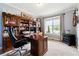 Well-appointed home office with custom built-ins, a spacious desk, and natural light from the window at 5070 Laurel Ridge Dr, Cumming, GA 30040