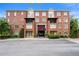 Red brick apartment building with manicured shrubs and multiple stories, with covered entry at 1735 Peachtree Ne St # 316, Atlanta, GA 30309