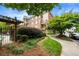 Beautifully landscaped condo exterior featuring brick facade, a pathway, and lush green trees at 1735 Peachtree Ne St # 316, Atlanta, GA 30309