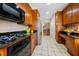 Galley kitchen featuring wood cabinets, black countertops, and stainless refrigerator at 1735 Peachtree Ne St # 316, Atlanta, GA 30309