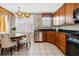 Eat-in kitchen with wood cabinets, stone countertops, stainless dishwasher, and a large window at 1735 Peachtree Ne St # 316, Atlanta, GA 30309