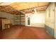 Basement with exposed ceiling, red painted floor, and shelving at 188 Thornbrooke Dr, Hiram, GA 30141