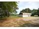 Commercial building with gravel parking area, lake view, and surrounded by trees at 188 Thornbrooke Dr, Hiram, GA 30141