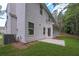 Exterior of home with patio, green lawn, mature trees, and a cooling system at 488 Charleston Pl, Villa Rica, GA 30180